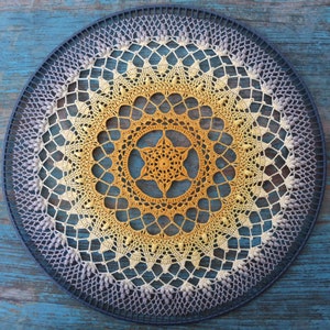 May include: A crocheted mandala wall hanging with a gradient of colors from purple to yellow. The mandala is circular and has a detailed design with a star in the center.