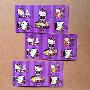 May include: Three purple and white sticker sheets featuring Hello Kitty dressed as a witch. Each sheet has four stickers with different images of Hello Kitty, including a cupcake, a cauldron, and a ghost. The text "HAPPY HALLOWEEN" is on one of the stickers.