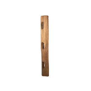 May include: A weathered wooden post with three rectangular holes cut into it. The post is brown and has a natural wood grain.