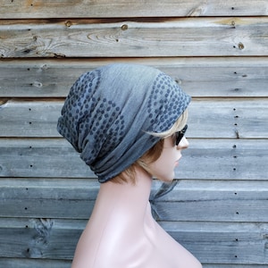 Pu&ograve; includere: Un berretto grigio con un motivo a pois neri. Il berretto &egrave; realizzato in un tessuto morbido ed elastico, perfetto per tenere la testa al caldo in inverno.