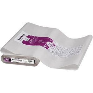 May include: A roll of HeatnBond Lite iron-on adhesive, with a white sheet of fabric partially unrolled. The packaging features a purple label with white text and a decorative swirl design. The roll is 43 cm wide.