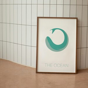 May include: A framed print with a teal blue whale illustration in the shape of a circle. The text "THE OCEAN" is printed below the whale.