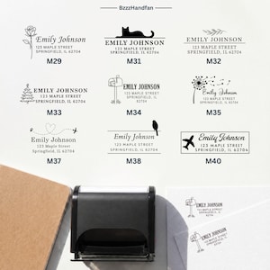 Peut inclure: Un tampon encreur noir automatique placé sous une grille de huit modèles d'adresses de retour personnalisés, étiquetés de M29 à M40. Chaque motif présente le nom Emily Johnson, une adresse et des illustrations à l'encre noire comme un chat.