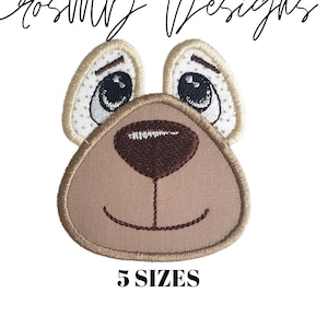 May include: Embroidered brown bear face with white eyes and a brown nose. The text "5 SIZES" is below the bear face.