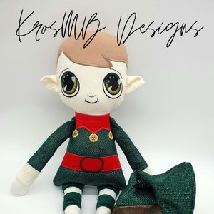 May include: A plush elf doll with green and white striped pants, a green shirt with a red belt, and a brown hat. The elf has brown hair, large green eyes, and a friendly smile. The doll is sitting on a white background.