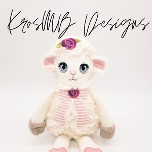 Puede incluir: Un juguete de peluche de cordero blanco con detalles rosas. El cordero tiene una rosa rosa en la cabeza, una bufanda a rayas rosa y blanca y corazones rosas en los pies. El cordero está sentado sobre un fondo blanco.