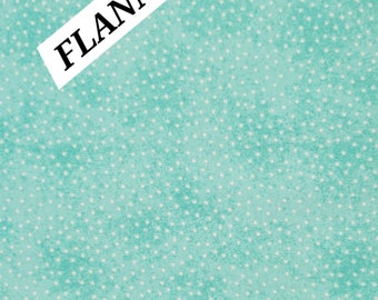 May include: A turquoise blue flannel fabric with a white polka dot pattern. The fabric has a slightly textured surface. The word "FLANNEL" is written in black on a white label.