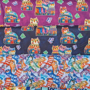 May include: A collection of colorful patterned fabrics featuring whimsical cat designs, floral patterns, and geometric shapes. The fabrics showcase a variety of colors, including blue, purple, orange, and green. The cat patterns include butterflies.
