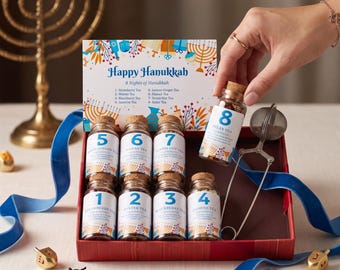 May include: A Hanukkah tea advent calendar set featuring eight small glass jars with cork stoppers, each labeled with a number and tea variety. The set includes a metal tea infuser, a decorative card titled Happy Hanukkah, and blue ribbons.