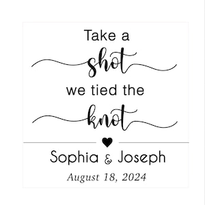 May include: A white background with black text that reads "Take a shot we tied the knot". Below the text is a heart symbol, followed by the names "Sophia & Joseph" and the date "August 18, 2024".