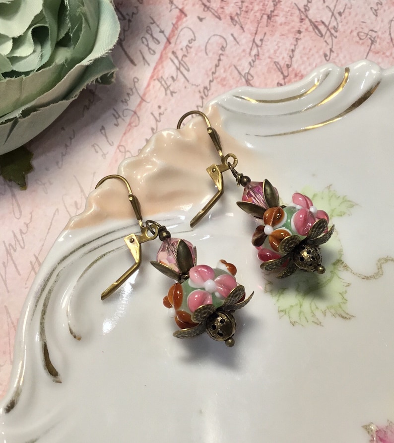 Murano lampwork pink green and rust glass beads with vintage pink crystal beads antique brass finish.