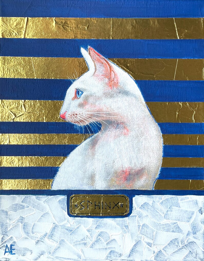 May include: A white Sphinx cat portrait on a canvas with blue and gold horizontal stripes. The cat has blue eyes and pink ears and nose. The word "SPHINX" is on a gold plaque at the bottom of the painting. The artist's initials are in the lower left corner.