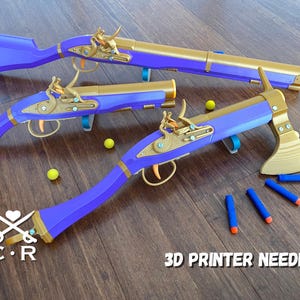 Peut inclure: Ensemble de jouets imprimés en 3D, comprenant un fusil, deux pistolets et une arme en forme de hache, de couleur violette et dorée. Le texte "3D PRINTER NEEDED" est visible. Des balles jaunes et des fléchettes bleues sont éparpillées.