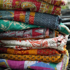 Puede incluir: Una pila de colchas kantha coloridas con intrincados patrones y costuras. Las colchas est&aacute;n hechas de saris reciclados y son una artesan&iacute;a tradicional india. Copyright@VillageWomenSkill