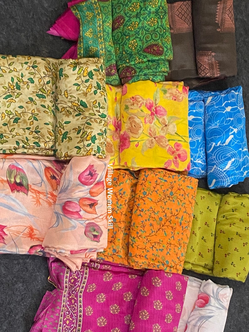 May include: A collection of colorful fabric squares with floral and geometric patterns. The fabrics are arranged in a pile on a gray surface. The text "Village Women Skill" is visible on one of the fabrics.