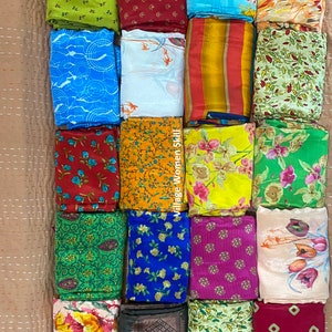 May include: A collection of 20 colorful fabric squares with various patterns, including floral, geometric, and abstract designs. The fabric squares are arranged in four rows of five squares each. The text "Village Women Skill" is visible on the right side of the image.