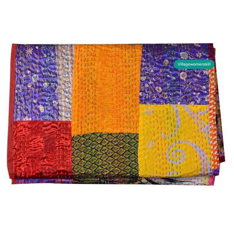 Pu&ograve; includere: Una trapunta colorata a patchwork realizzata con sari di seta riutilizzati. La trapunta presenta una variet&agrave; di colori, tra cui rosso, giallo, viola e verde. La trapunta &egrave; cucita a mano e ha un aspetto vintage unico.  "Villagewomenskill" &egrave; stampato nell'angolo in alto a destra.