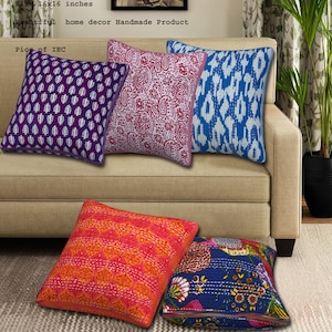 May include: Five colorful square throw pillows with different patterns on a beige couch. The pillows are made of cotton and have a kantha stitch design. The pillows are 16 inches by 16 inches.