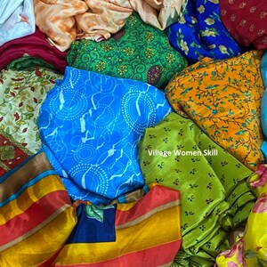 May include: A pile of colorful fabric scraps with various patterns, including floral, geometric, and striped designs. The fabrics are made of silk and are arranged in a random order. The text "Village Women Skill" is visible in the center of the image.