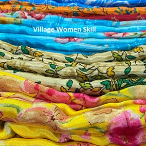 May include: A stack of colorful fabric with floral patterns. The fabric is folded and arranged in a rainbow pattern. The text "Village Women Skill!" is visible in the center of the image.