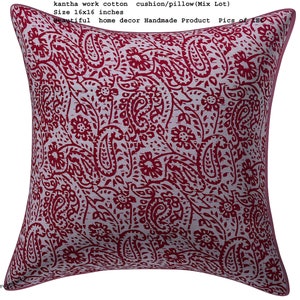 May include: A red and white kantha work cotton cushion or pillow with a paisley pattern. The cushion is 16 inches by 16 inches.