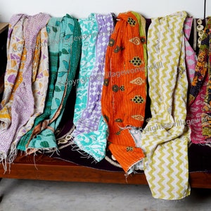 Może przedstawiać: Kolekcja kolorowych kołder kantha z r&oacute;żnymi wzorami, w tym kwiatowymi, geometrycznymi i paisley. Kołdry są wykonane z recyklingowanych sari i są szyte ręcznie. Copyright @villagewomenskill