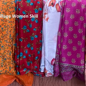 May include: A collection of eight colorful fabric scarves with floral patterns. The scarves are arranged vertically and have a variety of colors, including yellow, orange, red, blue, white, pink, and light blue. The text "Village Women Skill" is visible at the top of the image.