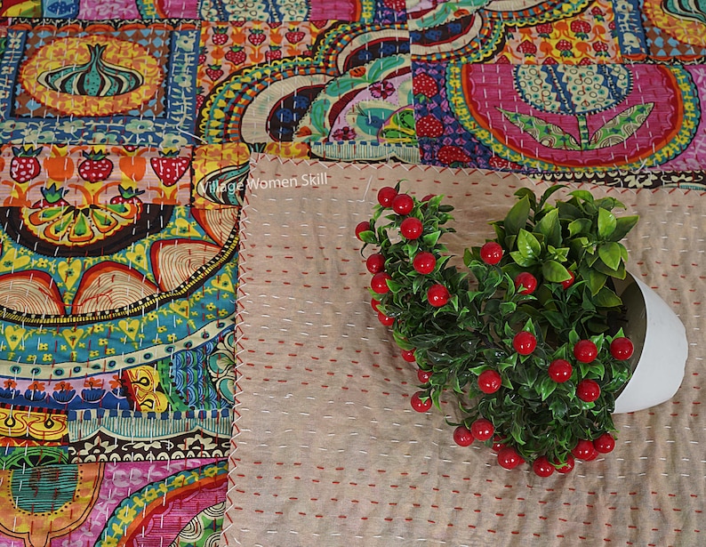 Puede incluir: Una colcha de retazos colorida con un patr&oacute;n floral. La colcha est&aacute; hecha de diferentes telas y est&aacute; cosida con una puntada corrida. La colcha est&aacute; colocada sobre una superficie beige con una peque&ntilde;a planta en maceta en la esquina.