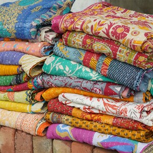 Puede incluir: Una pila de colchas kantha de colores con varios patrones florales y paisley. Las colchas est&aacute;n hechas de saris reciclados y est&aacute;n cosidas a mano. Copyright@VillageWomenSkill
