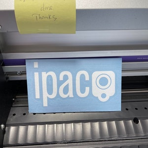 May include: A blue vinyl sticker with the word "ipaco" in white letters and a white circle with a black dot in the center.