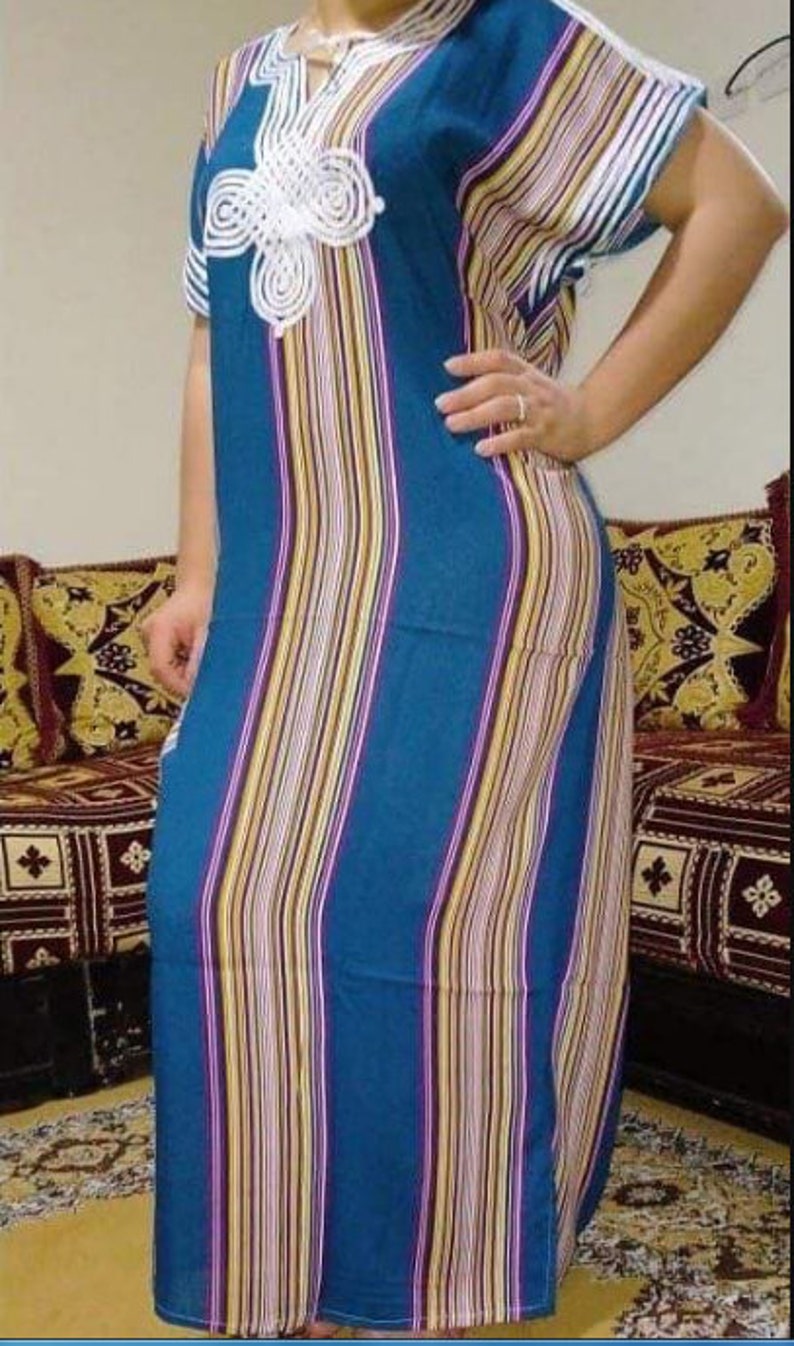 May include: A long, blue and white striped dress with a white crocheted design on the neckline. The dress has short sleeves and a loose fit.