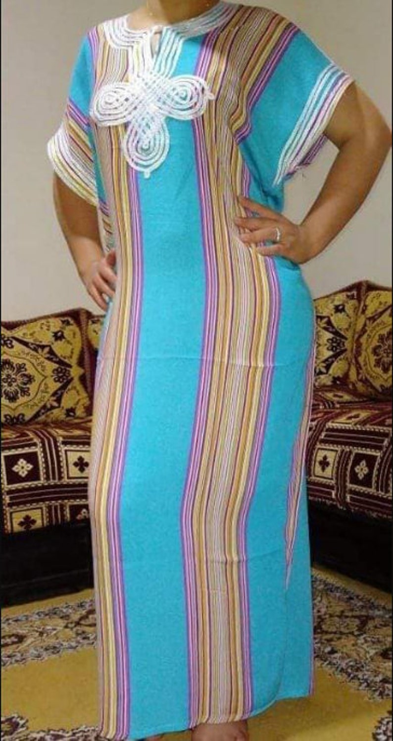 May include: A long, blue and white striped dress with a white crocheted design on the front. The dress has a loose fit and is made of a lightweight fabric.