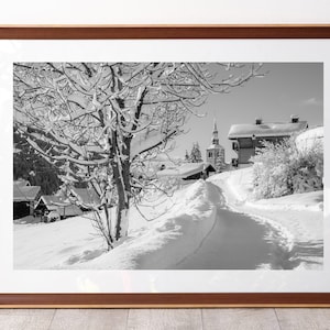 The mountain village of Saint-Nicolas-la-chapelle and its bell tower under the snow in black and white