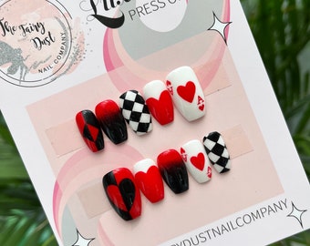 May include: Set of ten press-on nails with a playing card theme. The nails feature a black and white checkered pattern, red and black hearts, and the ace of spades. The nails are displayed on a white card with the text "Luxury Press On Nails" and "The Fairy Dust Nail Company".