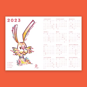Può includere: Un calendario 2023 con un coniglio dei cartoni animati in rosso, giallo e arancione. Il calendario comprende i mesi da gennaio a dicembre con i giorni della settimana etichettati. Il calendario include anche una sezione per le fasi lunari.