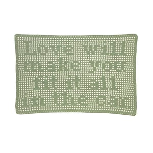 May include: Sage green crochet pillow with a rectangular shape. The open weave design creates a grid pattern with a repeating text design. The pillow is a decorative item for a bed or sofa.