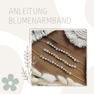 Könnte beinhalten: Drei weiße und grüne Perlenarmbänder mit Blumendesigns auf einer Holzoberfläche. Die Armbänder sind in einer Reihe angeordnet, wobei das obere Armband das längste und das untere Armband das kürzeste ist. Der Text "ANLEITUNG BLUMENARMBAND" ist im Hintergrund sichtbar.