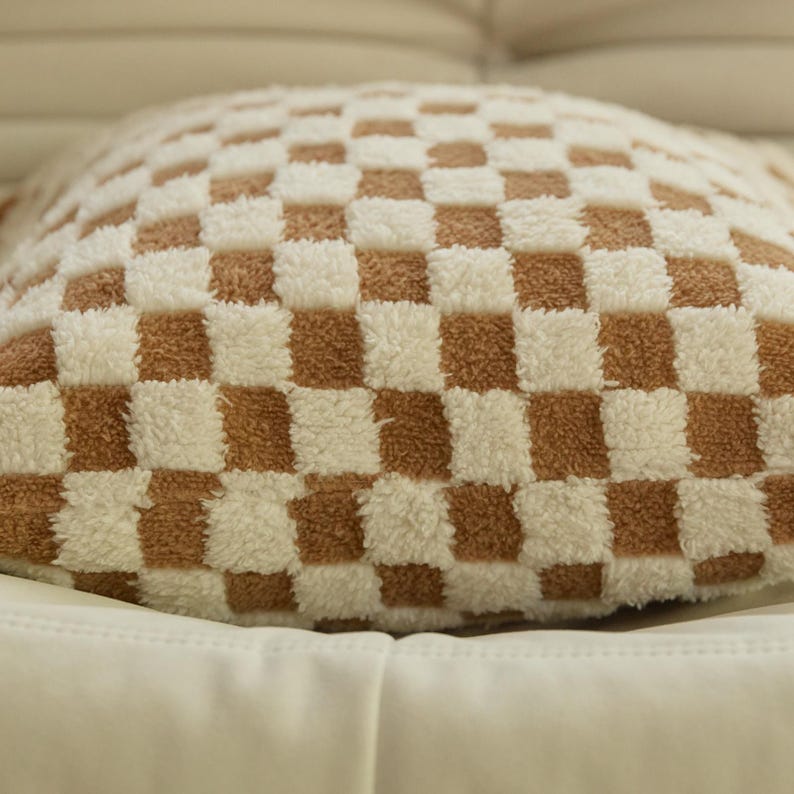 May include: A brown and white checkered throw pillow with a soft, fluffy texture.
