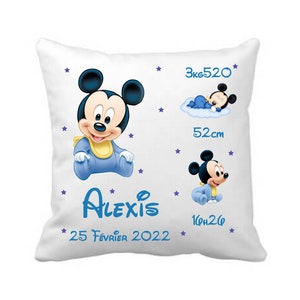 Peut inclure: Oreiller blanc avec un motif de bébé Mickey Mouse bleu et jaune. L'oreiller comprend également le texte "Alexis", "25 Février 2022", "3kg520", "52cm" et "16h26".