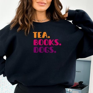 May include: Black sweatshirt with the text "TEA. BOOKS. DOGS." in a gradient of orange, pink, and purple.
