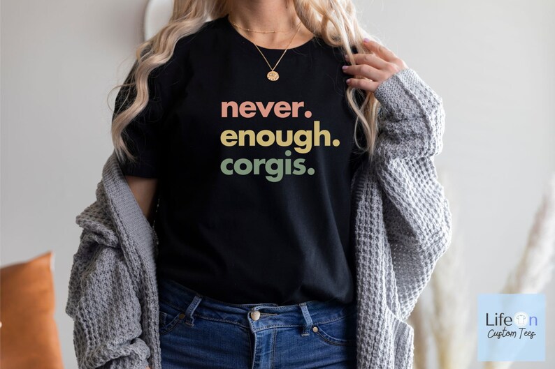 May include: A black t-shirt with the text "never. enough. corgis." in a rainbow gradient.