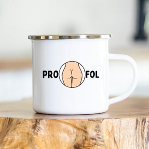Puede incluir: Taza de camping de esmalte blanco con un contorno negro de una vista trasera de una persona y las palabras "PRO" y "FOL" a cada lado del contorno.