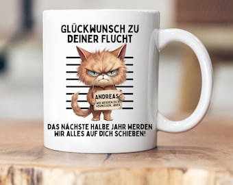 May include: White ceramic mug with a black and white illustration of an angry cat holding a sign that says "Andreas, wir werden dich vermissen...aber". The text on the mug reads "Glückwunsch zu deiner Flucht. Das nächste halbe Jahr werden wir alles auf dich schieben!"