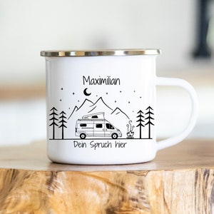 Könnte beinhalten: Weiße Emaille-Campingtasse mit einer schwarz-weißen Illustration eines Wohnmobils, Bergen, einem Lagerfeuer und Sternen. Der Text "Maximilian" und "Dein Spruch hier" ist auf die Tasse gedruckt.