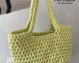 May include: A light green crochet tote bag with braided handles. The bag is made of a thick yarn and has a textured appearance. Text on the image reads "CROCHET PATTERN PDF instant download."