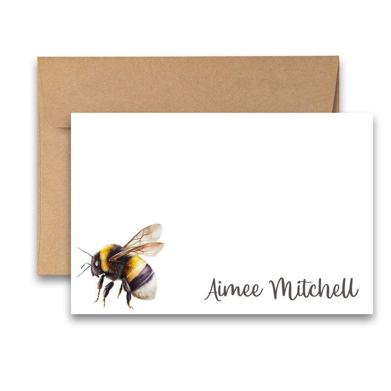 Puede incluir: Una tarjeta blanca con una ilustraci&oacute;n de abejorro negro y amarillo y el texto "Aimee Mitchell" en cursiva negra.