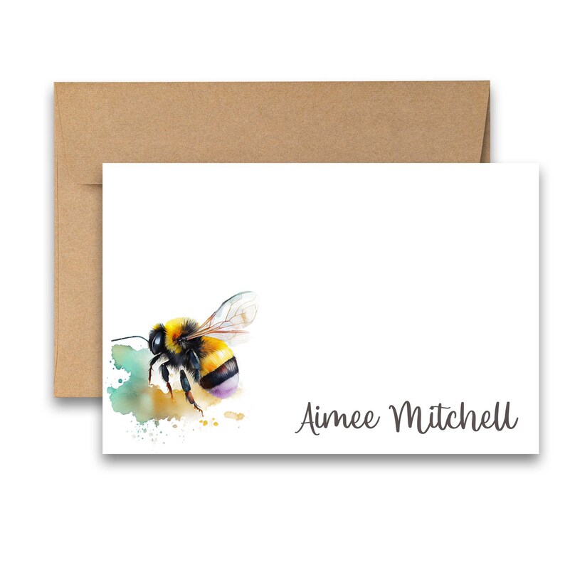 Puede incluir: Una tarjeta blanca con una pintura de acuarela de un abejorro sobre un fondo verde y amarillo. El texto "Aimee Mitchell" est&aacute; impreso en gris en la parte inferior de la tarjeta.