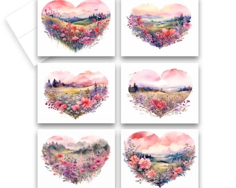 May include: A set of six greeting cards, each with a heart-shaped watercolour landscape design. The cards depict rolling hills, flowers, and trees in pink, purple, and green hues. White envelopes are included.