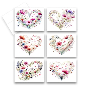May include: Set of six greeting cards with heart-shaped floral designs. Each card features a unique arrangement of colorful flowers, including pink, purple, and red blooms, forming a heart shape. White envelopes are included.