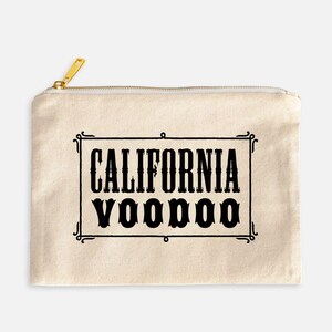 May include: A beige zippered pouch with the words "CALIFORNIA VOODOO" in a black, decorative font inside a black rectangular frame. The zipper is gold.